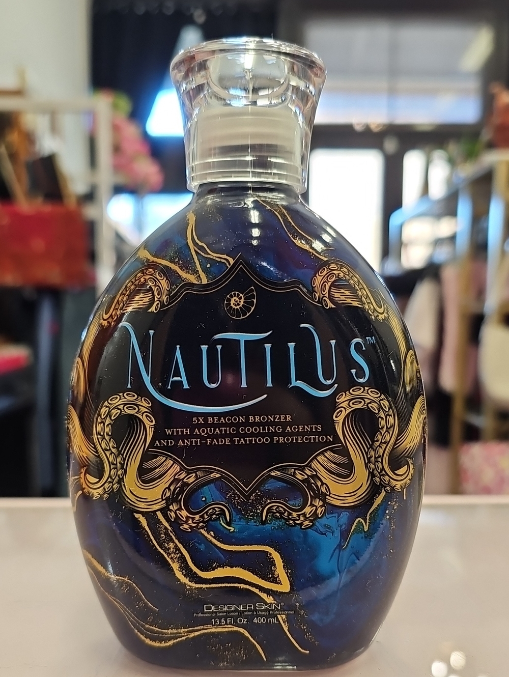Nautilus Tanning Bronzing Lotion in Deep Blue & Gold Accents. Designer Skin